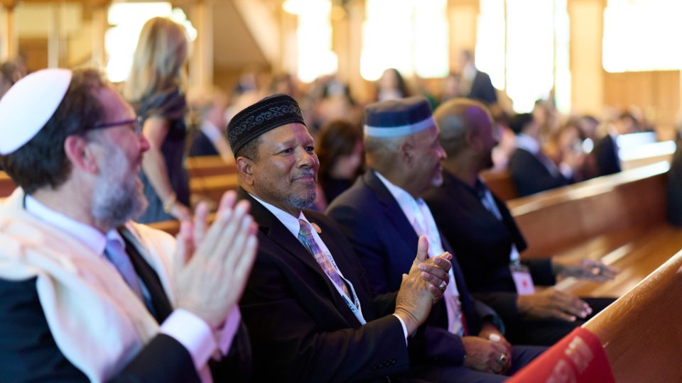 Faith leaders applauding in the Salt Lake Tabernacle