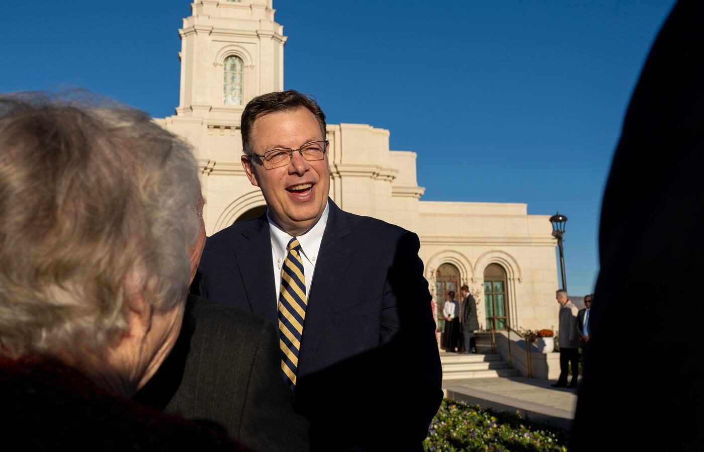 Elder Clark G. Gilbert smiling as he greets members outside the Cody Wyoming Temple