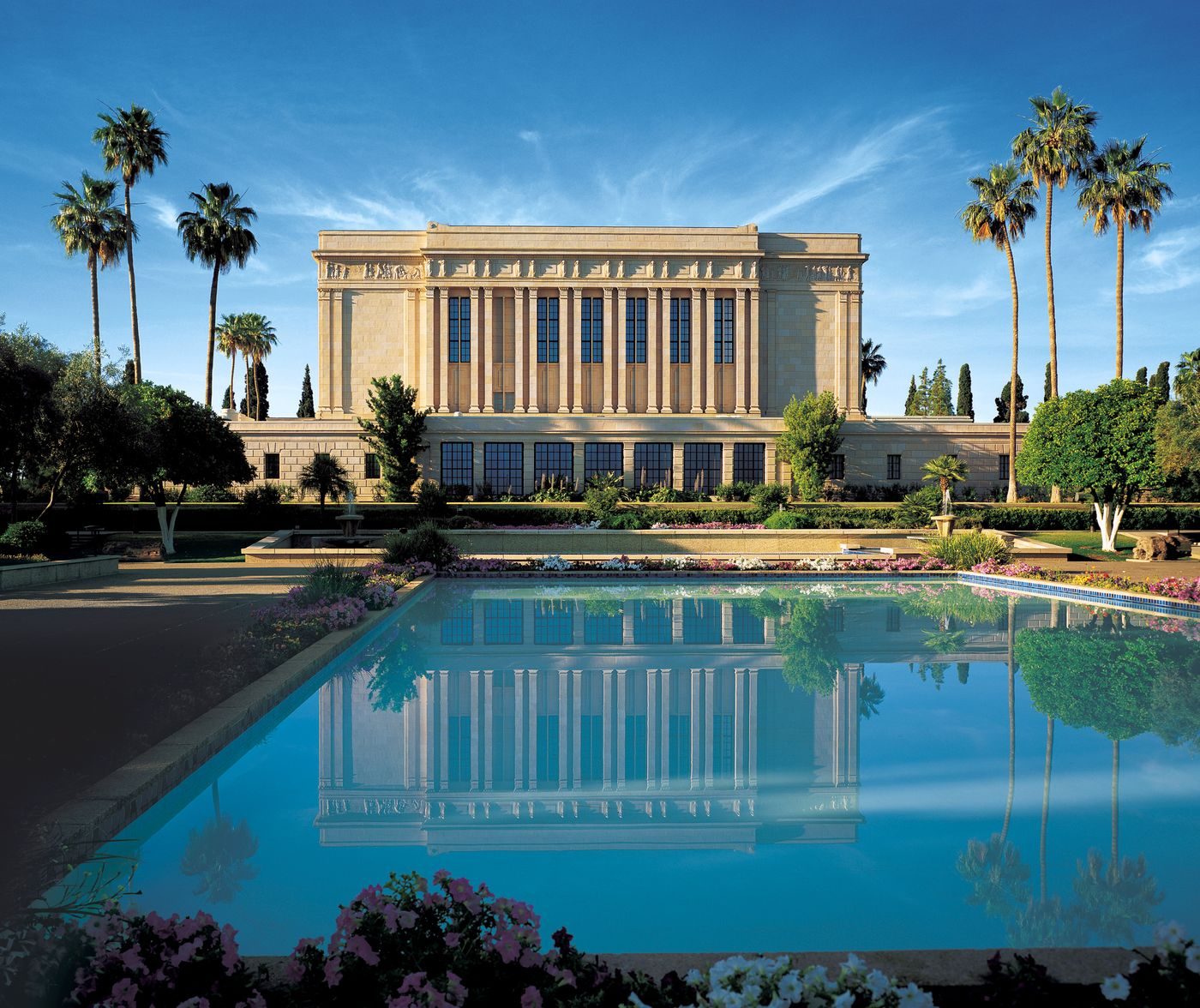 The Mesa Arizona Temple with palm trees reflected in its long pool