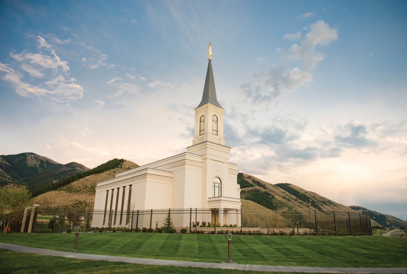 The white Star Valley Wyoming Temple with its single spire below green mountains