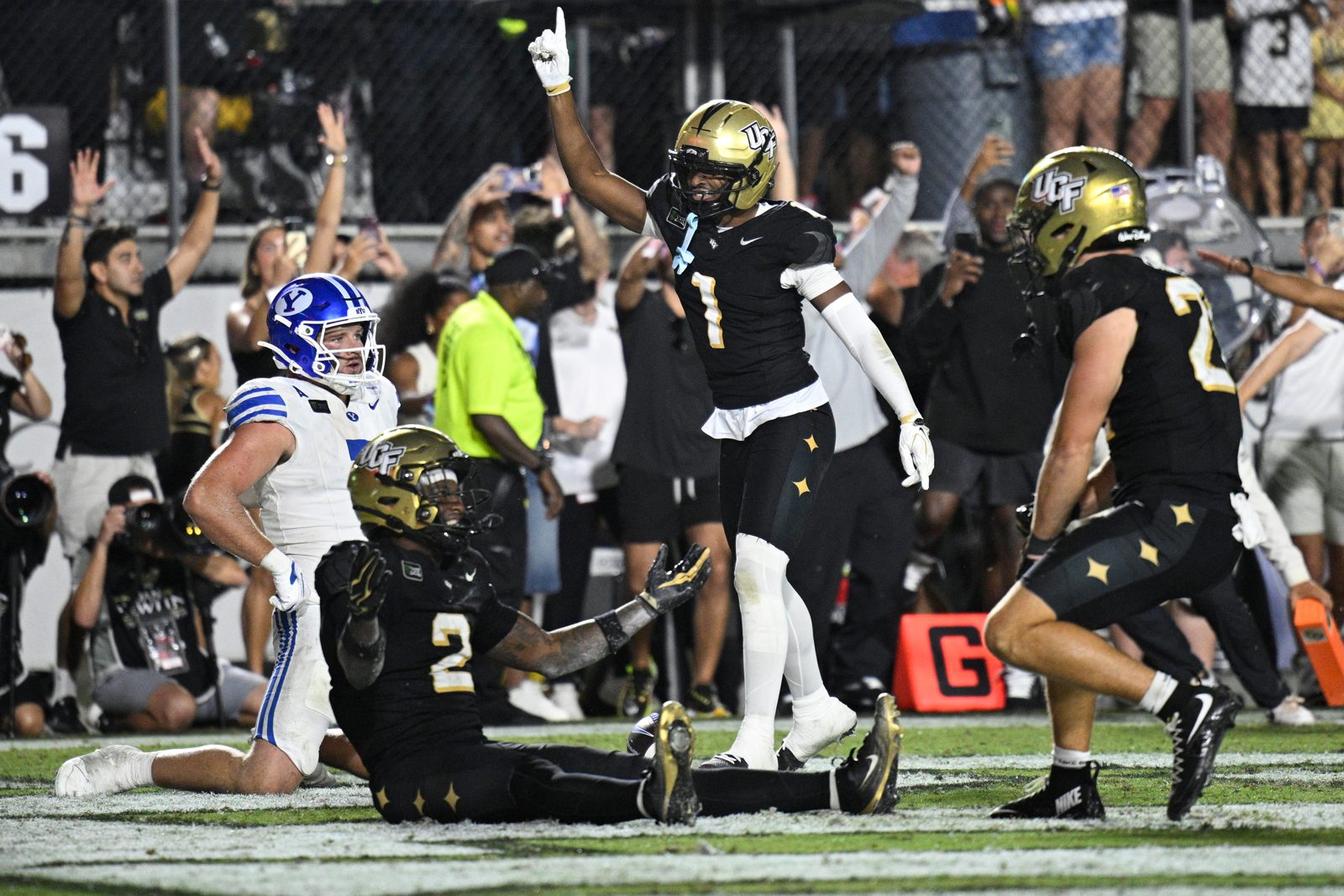 BYU tight end Walker Lyons looks on as UCF defenders celebrate after the final play of the second overtime